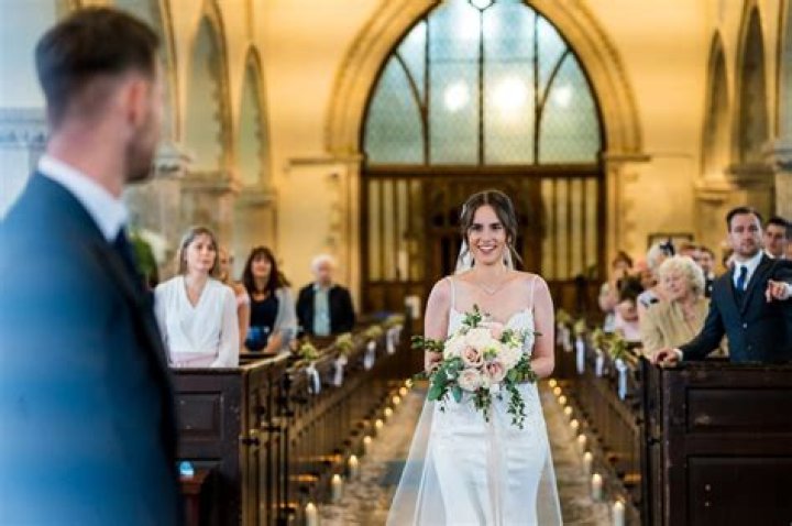 Who walks the mother of the bride down the aisle Catholic?
