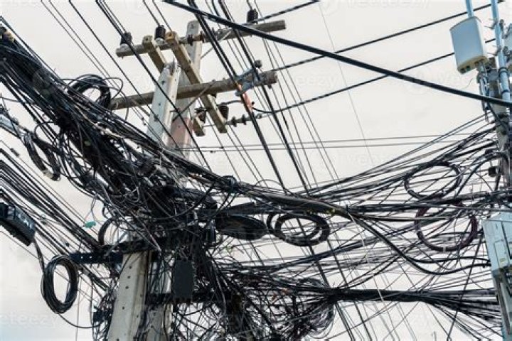 Why do wires hang loosely on poles in summer?