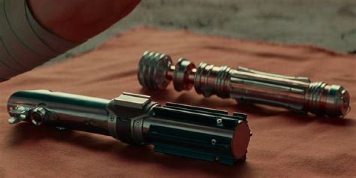 Why does Rey bury Luke and Leia's lightsaber?